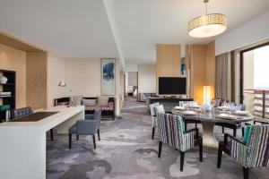 a living room with a table and chairs in a room at Four Points by Sheraton Guangdong, Heshan in Heshan