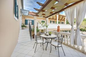 a patio with a table and chairs on a balcony at Villa Danica ZadarVillas in Sukošan
