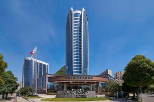 a tall building in front of a city at Four Points by Sheraton Liupanshui in Shuicheng
