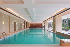 a large swimming pool in a building with a large window at Four Points by Sheraton Guangdong, Heshan in Heshan