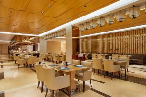 um restaurante com tectos e mesas e cadeiras de madeira em Four Points by Sheraton Liupanshui em Shuicheng
