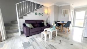 sala de estar con sofá púrpura y mesa en Casa Find Marbella - beautiful holiday home duplex apartment, en Marbella