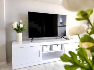 un centro de entretenimiento blanco con TV de pantalla plana en Casa Find Marbella - beautiful holiday home duplex apartment, en Marbella