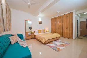 a bedroom with a bed and a blue couch at Lifeline Villas - The Secret Place Lonavala With Huge Pool And Lawn Area in Lonavala