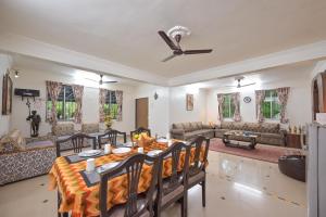 a living room with a table and chairs and a couch at Lifeline Villas - The Secret Place Lonavala With Huge Pool And Lawn Area in Lonavala