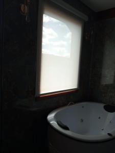 a bathroom with a window and a bath tub at Hotel Villa Greenberg in Monte Verde