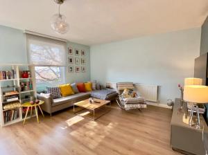 sala de estar con sofá y mesa en Superhost's Amazing Spacious Flat with Great Links, en Londres