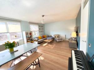 a living room with a table and a piano at Superhost's Amazing Spacious Flat with Great Links in London