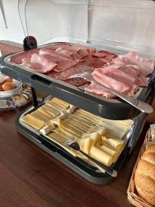 a display case with meats and cheese and bread at Penzion pod lesem in Most