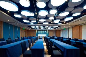 a row of chairs in a room with lights on the ceiling at Aloft Dongguan Songshan Lake in Dongguan