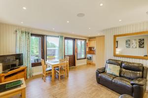 uma sala de estar com um sofá e uma mesa em Birch Lodge 16 em Newton Stewart