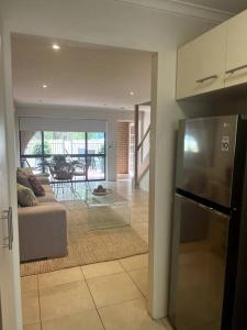 a kitchen and a living room with a refrigerator at A touch of lux in the Redlands! in Capalaba