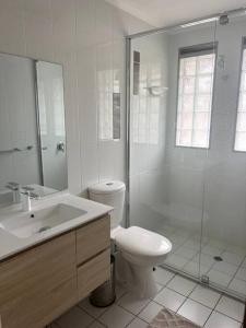 a white bathroom with a toilet and a shower at A touch of lux in the Redlands! in Capalaba