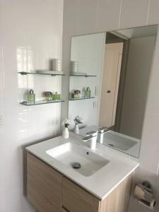 a white bathroom with a sink and a mirror at A touch of lux in the Redlands! in Capalaba