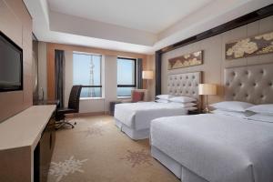 En eller flere senger på et rom på Sheraton Daqing Hotel