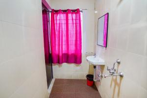 a bathroom with a pink shower curtain and a sink at FabExpress Lloyds Inn I in Chennai