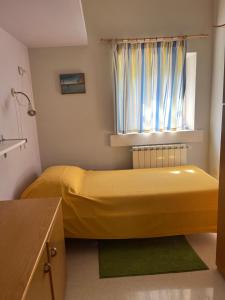 - une chambre avec un lit jaune et une fenêtre dans l'établissement Casa Vacanze “ Il Tiglio”, à Caiazzo