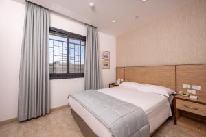 Un dormitorio con una cama grande y una ventana en Golden Walls Hotel, en Jerusalén