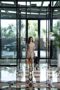a woman with a dog walking into a building at Pullman New Delhi Aerocity- International Airport in New Delhi