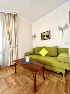 a living room with a green couch and a table at Апартаменты в самом центре столицы. in Kyiv