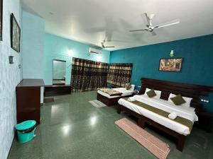 1 dormitorio con 2 camas y pared azul en Pench Tiger Home, 