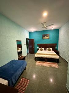 1 dormitorio con 2 camas y pared azul en Pench Tiger Home, 