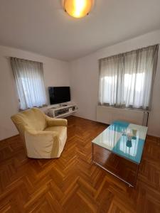 sala de estar con silla y mesa de cristal en Burle Apartment with FREE private parking, en Medulin