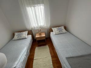 Habitación con 2 camas y mesa con ventana en Burle Apartment with FREE private parking, en Medulin