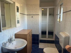 Un baño con lavabo, ducha e inodoro. en Burle Apartment with FREE private parking, en Medulin 11 fotos más