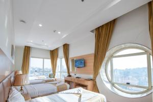 a bedroom with two beds and a large window at Alolayan Diamond Hotel in Mecca
