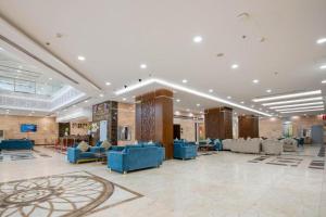 a lobby with blue chairs and tables in a building at Alolayan Diamond Hotel in Mecca