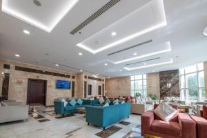 a large lobby with couches and tables and windows at Alolayan Diamond Hotel in Mecca