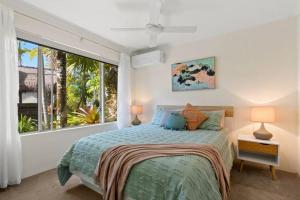 a bedroom with a bed and a large window at Noosaville Tropical Islander Resort in Noosaville +20 photos