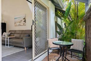 a screened in porch with a couch and a table at Noosaville Tropical Islander Resort in Noosaville