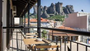 a table and chairs on a balcony with a view of mountains at ALBA SUITE APARTMENT in Kalabaka