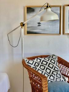 a floor lamp sitting next to a chair with a pillow at Casa Azul in Nazaré