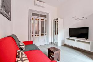 a living room with a red couch and a tv at Domvs Romae Apartment in Rome
