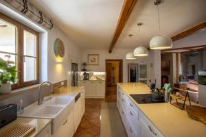 a large kitchen with white counters and sinks and windows at 7 Bedroom Secluded Villa close to Prague in Ricany
