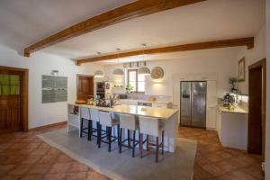 a large kitchen with a large island with bar stools at 7 Bedroom Secluded Villa close to Prague in Ricany