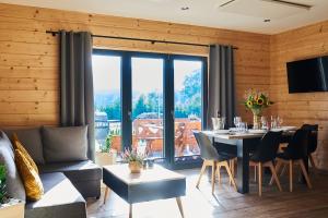 ein Wohnzimmer mit einem Tisch und einem großen Fenster in der Unterkunft Osada Orlica 1 in Lasowka