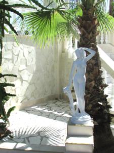 a statue of a woman playing tennis in a garden at Castellino Studios in Faliraki