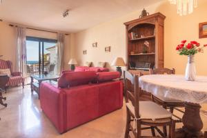 uma sala de estar com um sofá vermelho e uma mesa em 2233-Lovely 2 bedrooms on the beach, pool and port em Manilva