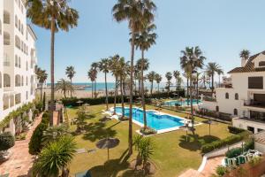 an aerial view of a resort with a pool and palm trees at 2233-Lovely 2 bedrooms on the beach, pool and port in Manilva