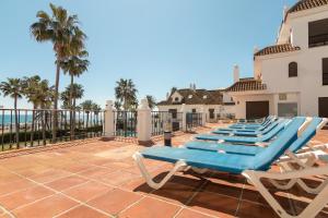 マニルバにある2233-Lovely 2 bedrooms on the beach, pool and portの青いラウンジチェアが並ぶパティオ