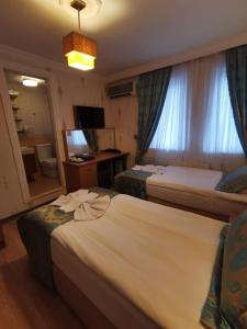 イスタンブールにあるアゴラ ブティック ホテル ＆ ビストロのベッド2台と窓が備わるホテルルームです。