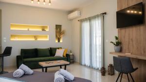 a living room with a green couch and a table at AURORA SUITE APARTMENT in Kalabaka