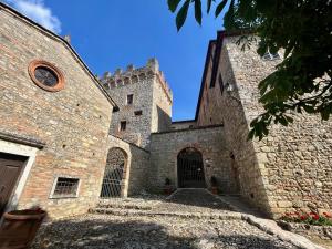ein altes Steingebäude mit einem Tor und einem Schloss in der Unterkunft Castel Pietraio in Monteriggioni