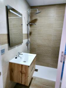 a bathroom with a sink and a shower with a mirror at Hostal Restaurante el cruce in Padul