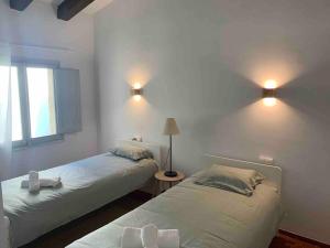 2 camas en una habitación con luces en la pared en Fantàstica casa amb jardí en plena COSTA BRAVA, en Santa Cristina d'Aro