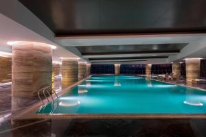 una gran piscina de agua azul en un edificio en Sheraton Changchun Jingyuetan Hotel, en Changchún